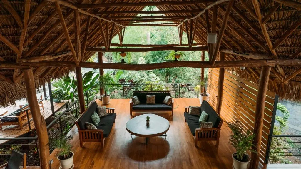 An open bamboo lounge at TreeCasa with sofas, low tables and a high thatched roof — set up for circle conversations